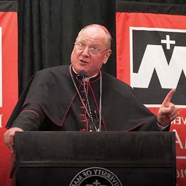 Cardinal Dolan at podium addressing students and guests